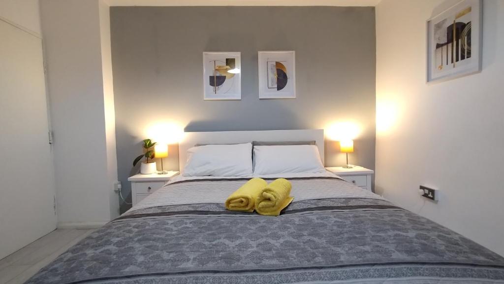 伯明翰Entire 4-Bed House & Parking, Steps from ICC & City-Center & Broad Street的一间卧室配有一张黄色毛巾的床