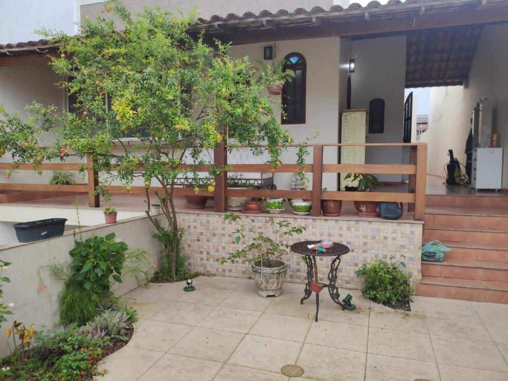 卡波布里奥Casa de praia em Cabo Frio até 12 hospedes的庭院设有桌子和盆栽树木