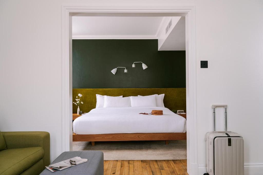 伦敦Sonder Chelsea Green的卧室配有白色的床和绿色的墙壁