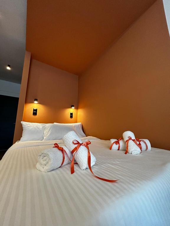 阿格里尼翁Orange Luxury apartment in agrinio的一张带白色毛巾和红色弓的床铺