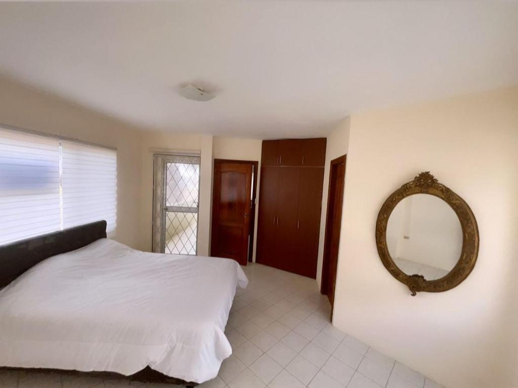 萨利纳斯Suites- Salinas的卧室配有一张床,墙上设有镜子