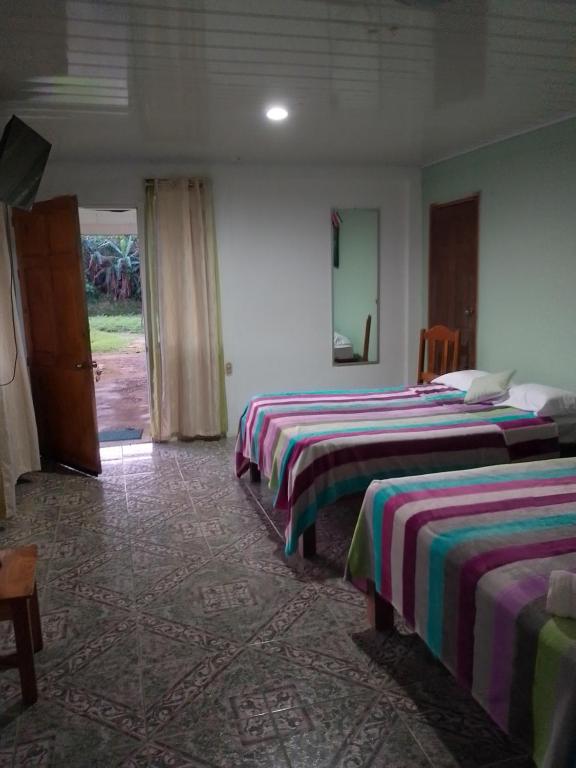 比加瓜Habitacion en Bijagua的一间酒店客房,设有三张床和一扇门