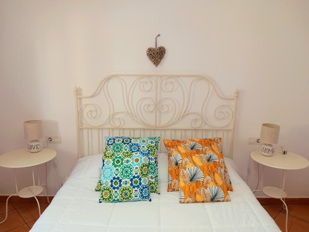 维拉韦德Casa Yahshua的一张带枕头的白色床和两张桌子