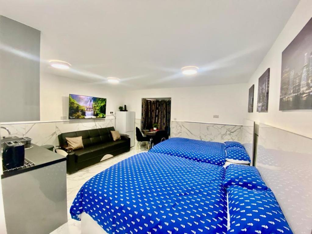 海斯THE ROYAL BOUTIQUE STUDIO by LONDON SLEEP 6的一张大蓝色的床,位于一个配有沙发的房间