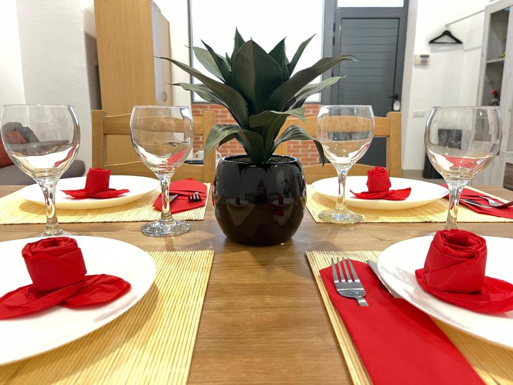 瓦伦西亚☆The Central Valencia Stay☆的一张桌子,上面有红餐巾和眼镜,上面有盆栽植物