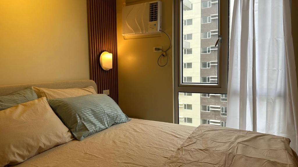 伊洛伊洛Iloilo Travellers Zen Zone的一间卧室设有一张床,窗户与大楼相连