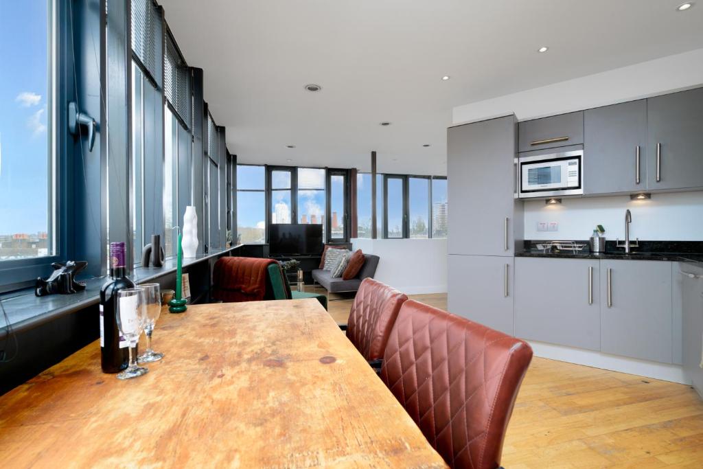 伦敦Luxury Central London Penthouse的厨房以及带木桌和椅子的用餐室。