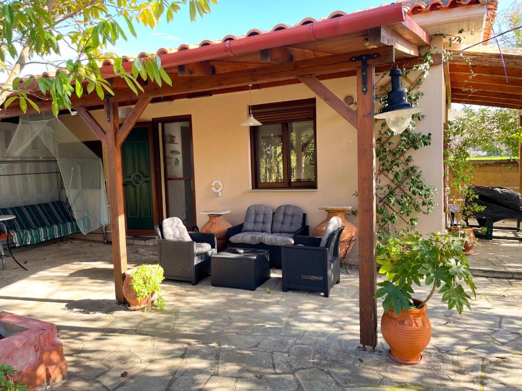 阿尔加拉斯蒂Your Home in Argalasti的凉棚下带沙发和椅子的庭院