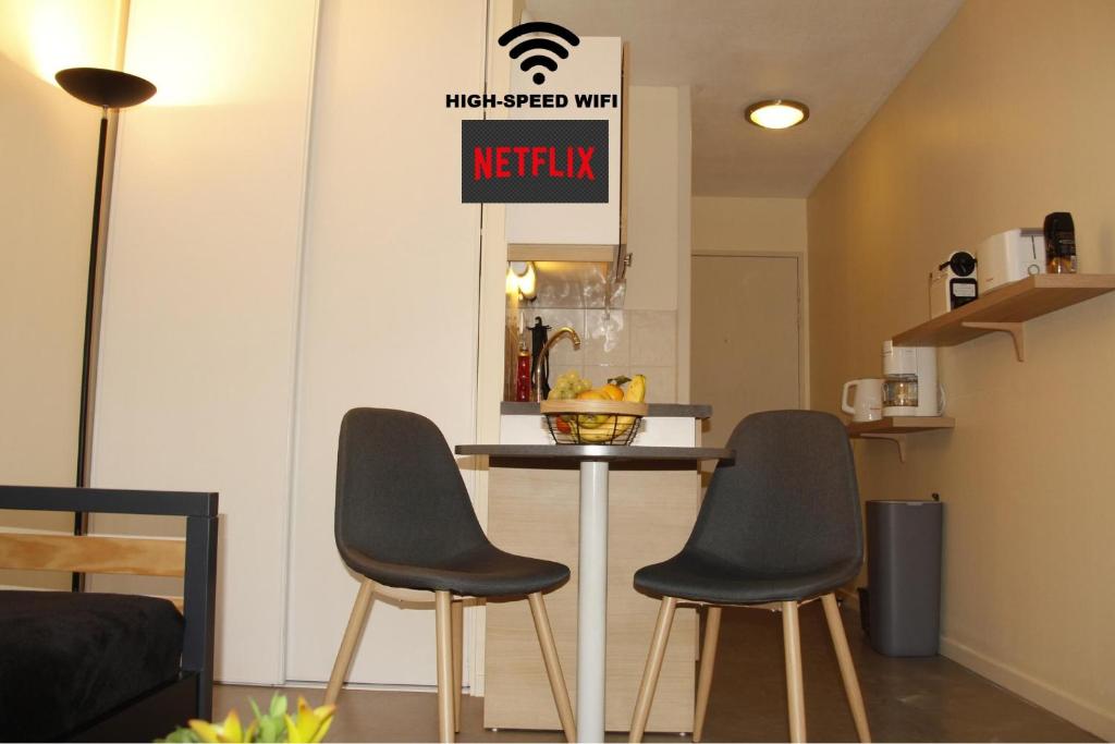 格勒诺布尔Grenoble hyper-centre + WiFi + Netflix的厨房配有两把椅子和一张带标志的桌子