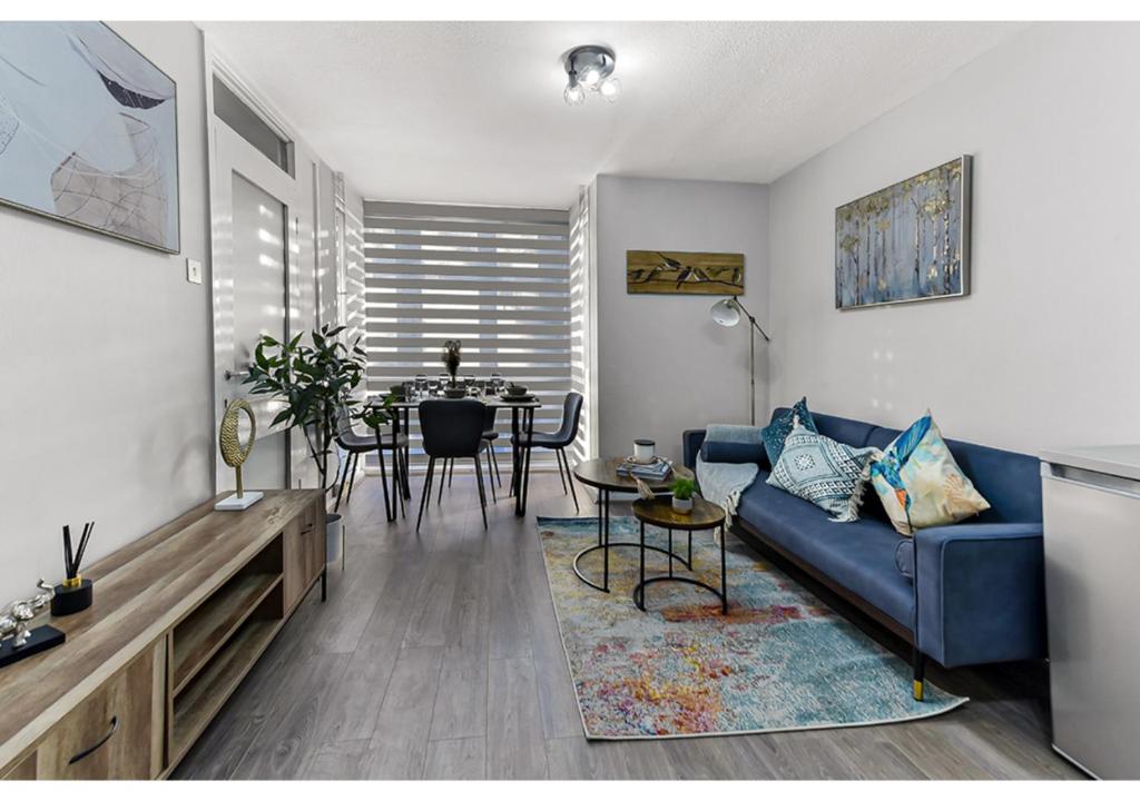 伦敦City Oasis - 1 BD Flat in Central Location的客厅配有蓝色的沙发和桌子