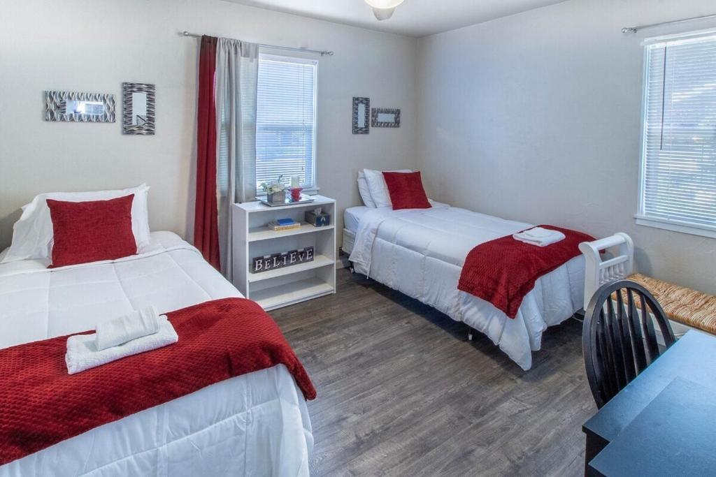 雷丁House of Favor的一间卧室配有两张带红白毯子的床