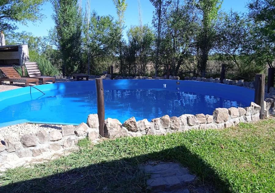 GualeguaychúValdemoro Hosteria的一座蓝色的大型游泳池,四周环绕着石墙