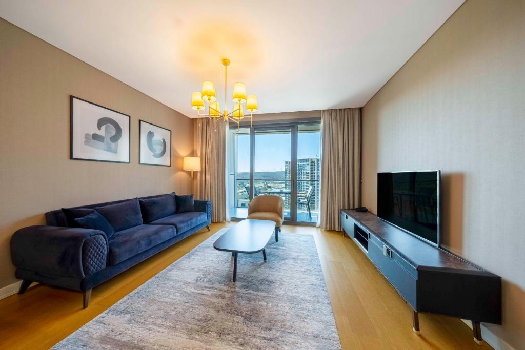 伊斯坦布尔Radisson Residences Vadistanbul的客厅配有蓝色的沙发和电视