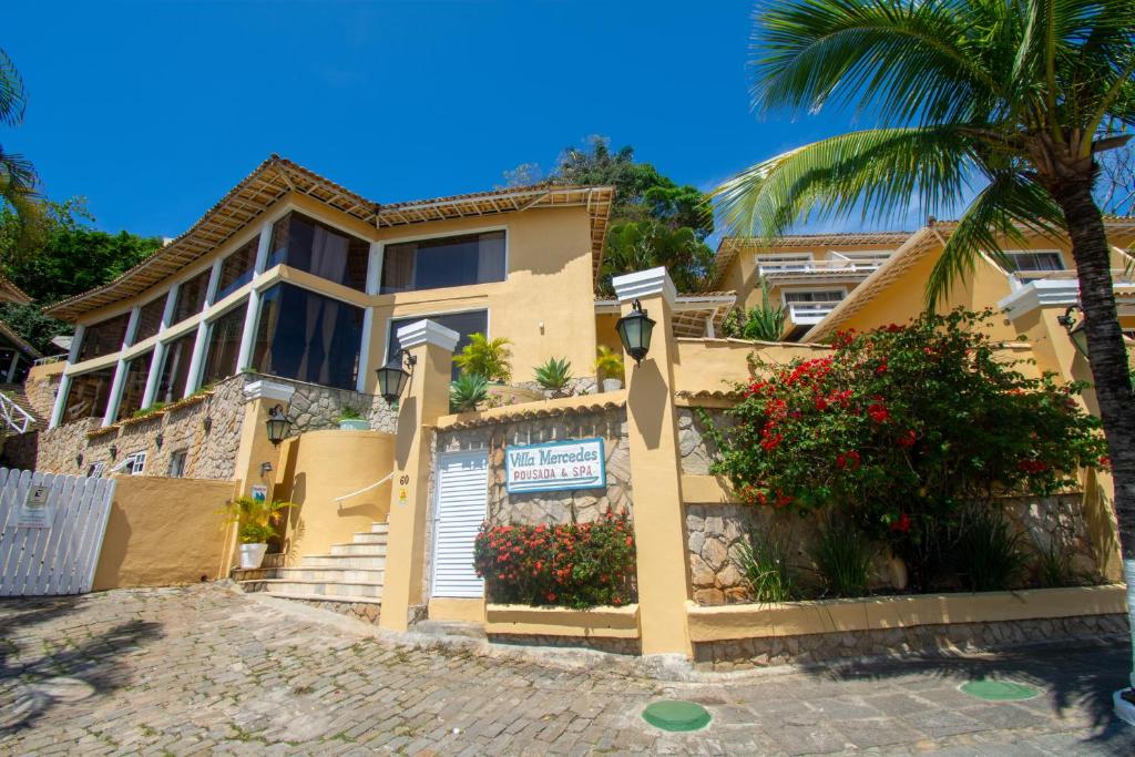 布希奥斯Pousada e Spa Villa Mercedes by Latitud Hoteles的前面有棕榈树的房子
