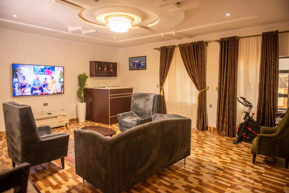 OnitshaAbada Luxury Hotel and Suites的客厅配有沙发和两把椅子