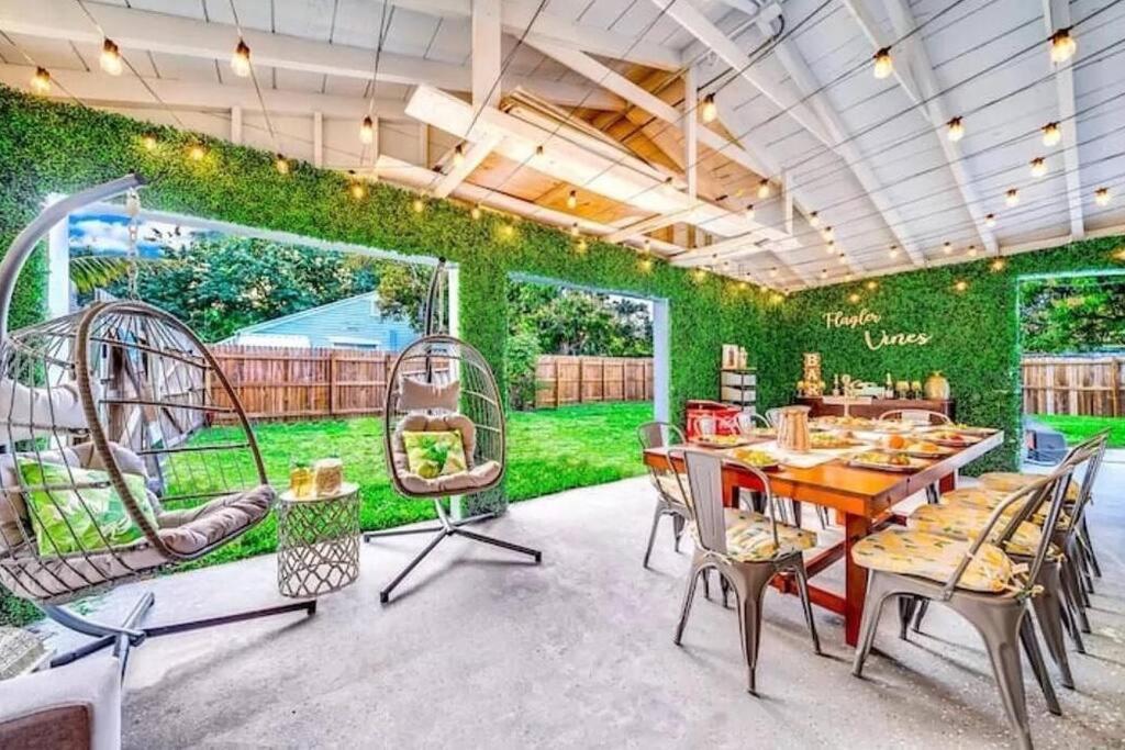 西棕榈滩Rockaway Beach House的一间设有绿色墙壁、桌子和椅子的用餐室