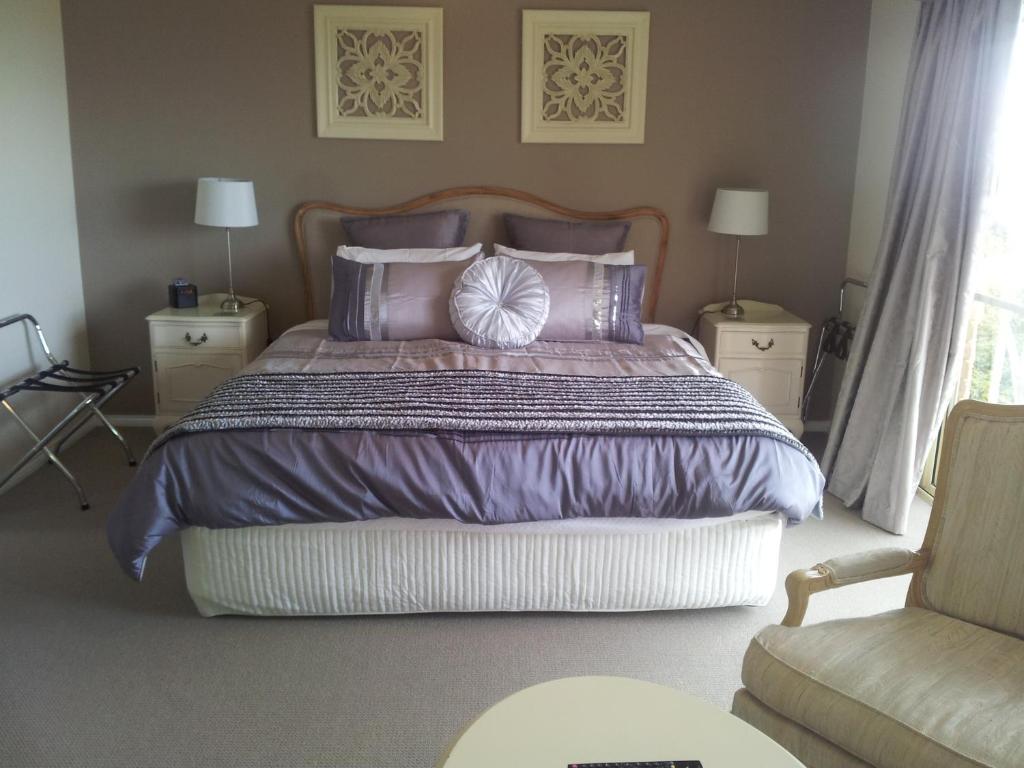 Margate水景花园住宿加早餐旅馆的一间卧室配有一张大床,提供紫色床单和枕头