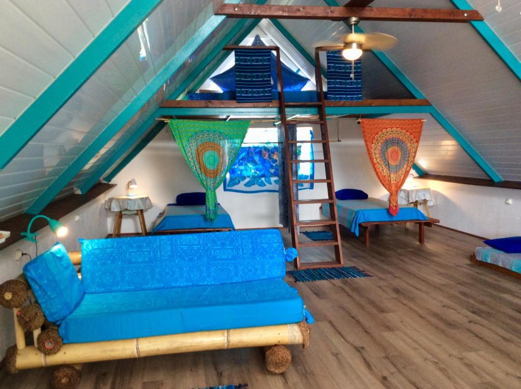 AfaahitiL'Auberge de Tahiti Iti - Beach hostel的一间带蓝色沙发的客厅和一个阁楼