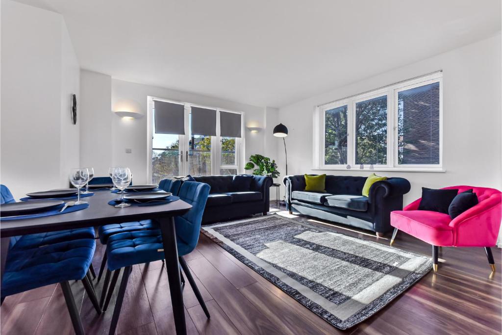 伦敦Charming and Modern 2 BR Flat的客厅配有桌子和蓝色椅子