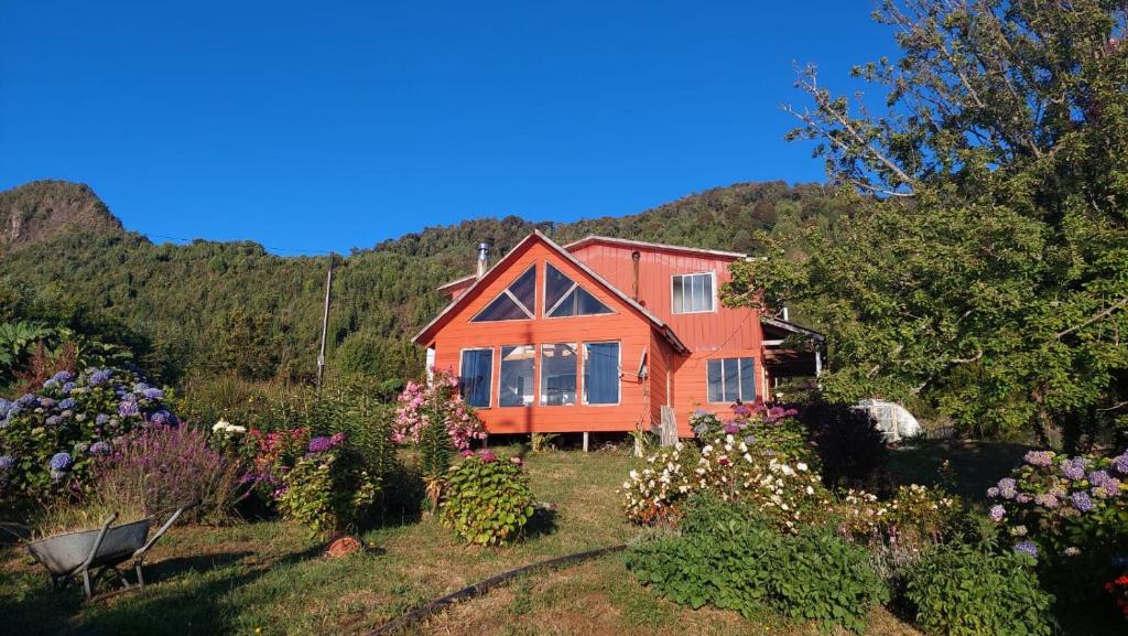 蒙特港Cabaña Frente Al mar, Carretera Austral km 38,6, Puerto Montt的花园中种满鲜花的房子