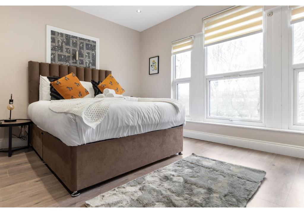 伦敦Brand New Homey and Stylish Perfect for Travellers的一间卧室设有一张大床和两个窗户。
