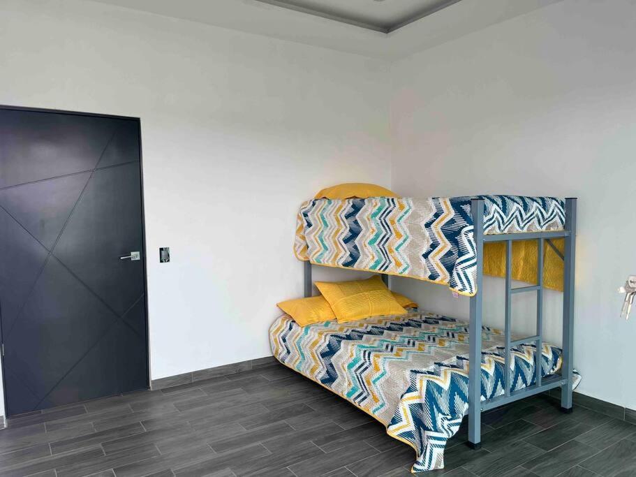 尧特佩克Casa Maya的客房配有带黄色枕头的双层床。