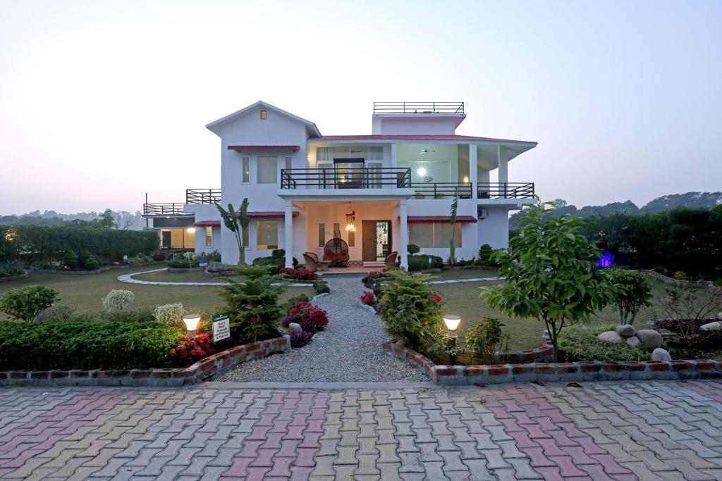 JhirnaHriday Bhoomi - Luxury Cottages & Villa in Jim Corbett的前面有砖瓦车道的房子
