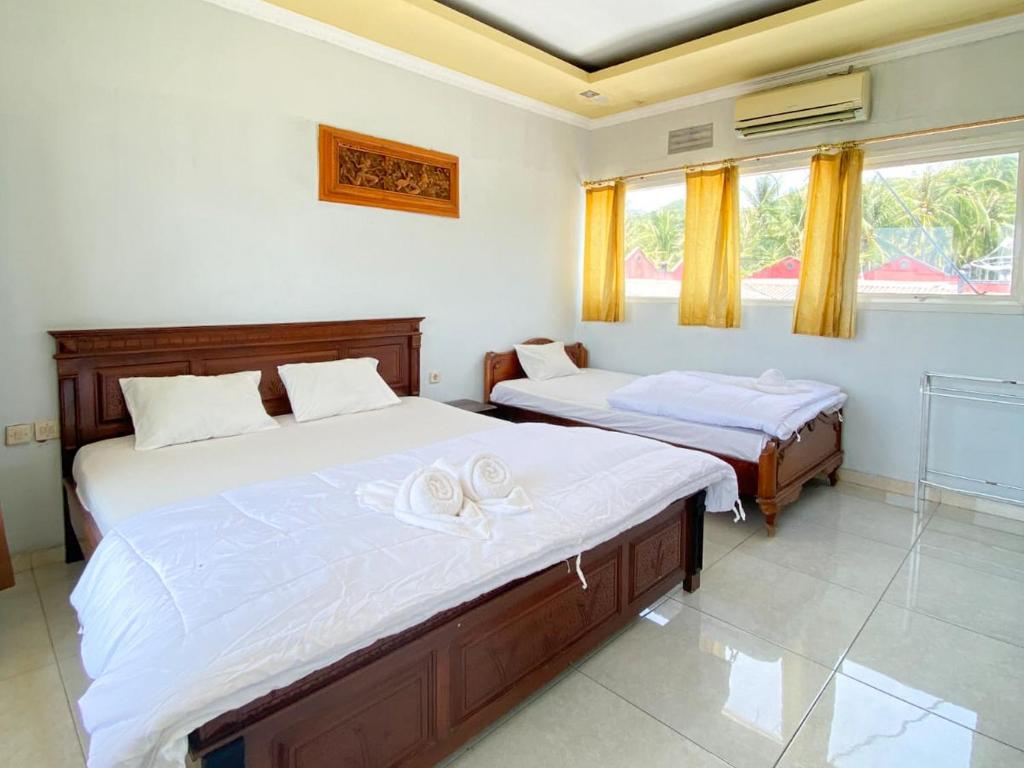 卡里蒙贾瓦Puri Karimunjawa RedPartner的一间卧室设有两张床和窗户。