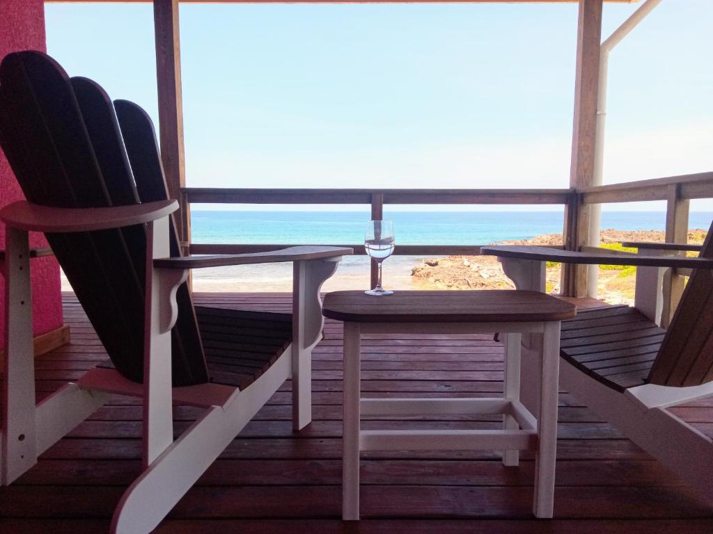 乌蒂拉Casa Corazon Striking Beach Home的一个带两把椅子和一张桌子的门廊,享有海滩美景