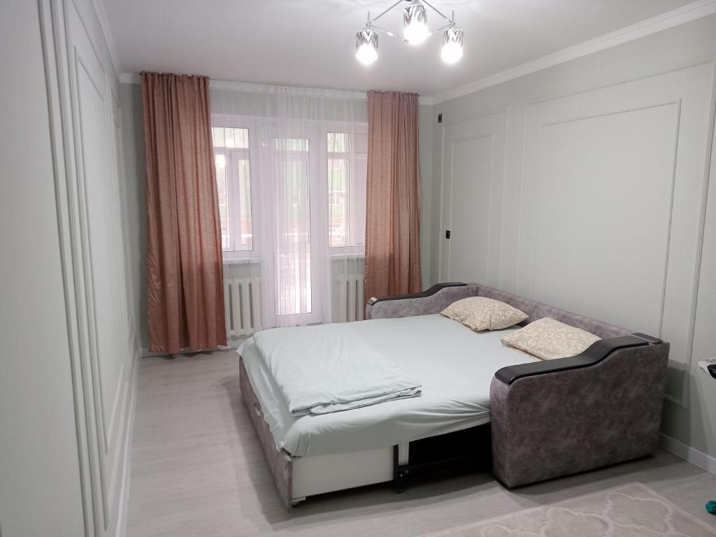奎兹洛达Orda的一间设有床铺的卧室,位于带窗户的房间内