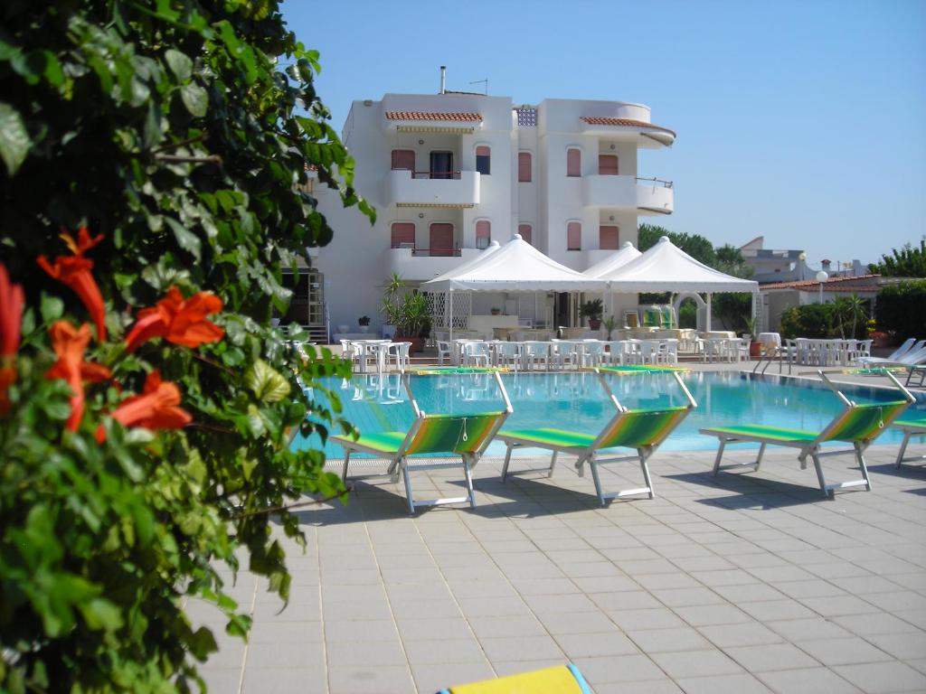 莱波拉诺亚特兰堤公寓酒店的一个带椅子的游泳池和一个背景建筑