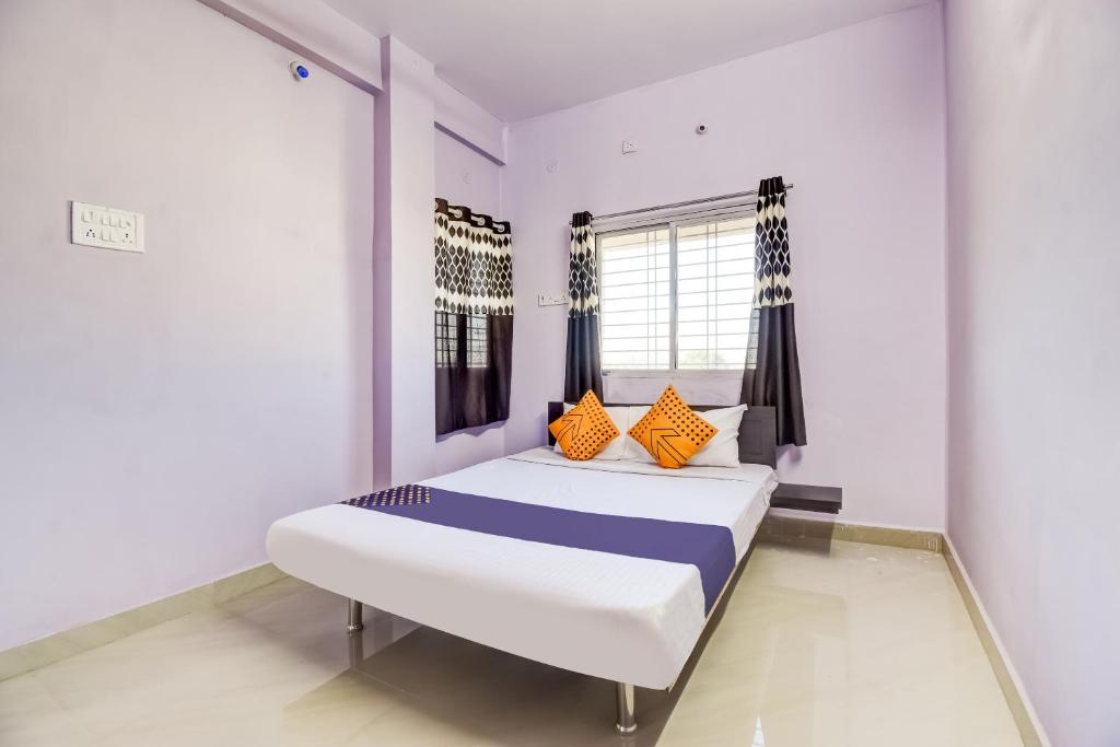 BhandāraSPOT ON The Highway Inn的一间卧室配有带橙色和蓝色枕头的床