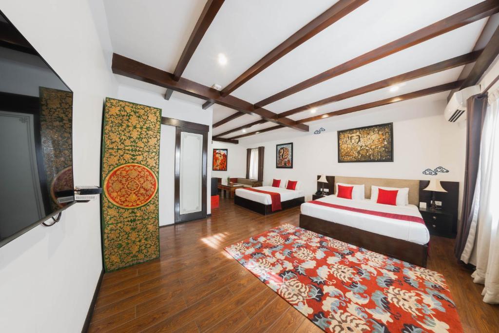 加德满都达赖拉精品酒店的一间卧室配有两张床和一台平面电视