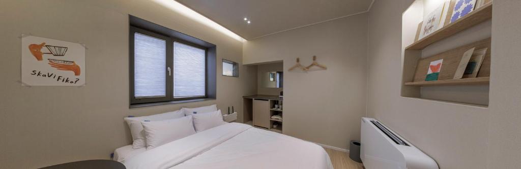 顺天市Stay Dooroo的卧室配有白色的床和窗户。