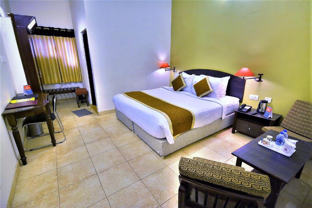 焦特布尔Rajputana Palace的酒店客房设有一张大床和一张书桌。