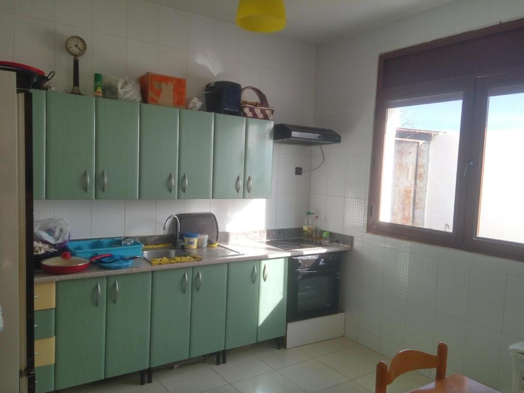 Villa Alhucemas的厨房配有绿色橱柜和水槽