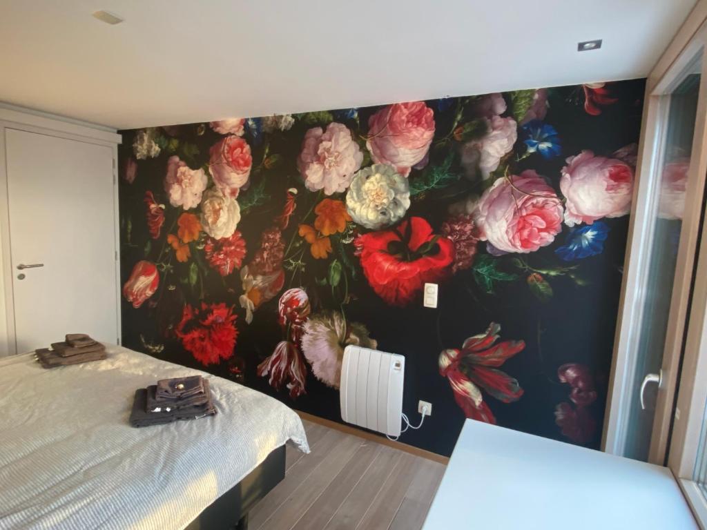韦姆CHAMBRES PERCHEES的卧室的墙上挂着花卉壁画