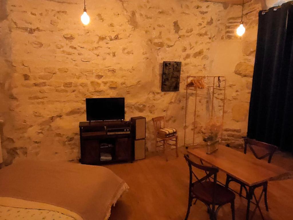昂斯Chamade en Beaujolais的客厅配有桌子和电视