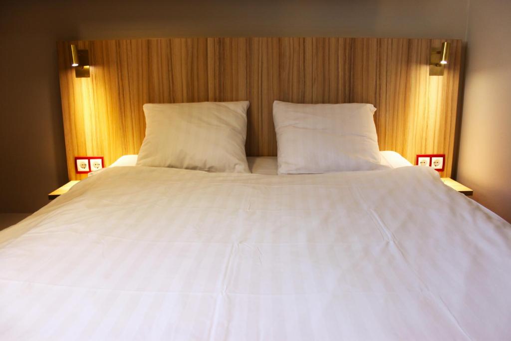 韦斯特罗斯韦斯特罗斯早安酒店的一张带两个枕头的大白色床
