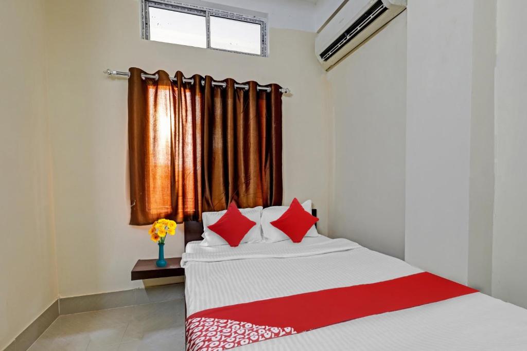 DispurOYO Flagship Lucky 7的一间卧室配有一张带红色枕头的床和一扇窗户
