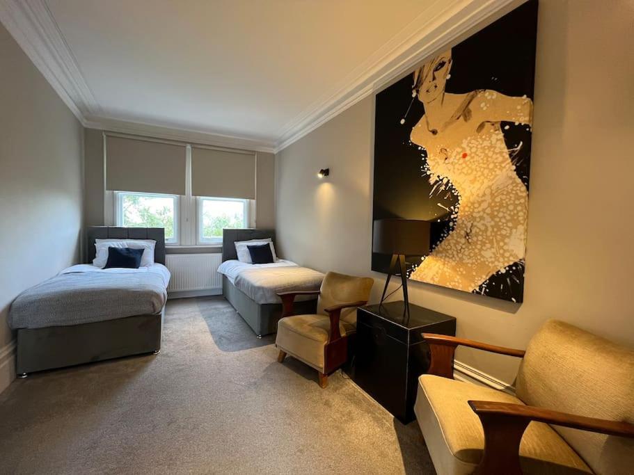 伦敦Star London Warwick Mansions 3-Bed Oasis的酒店客房,设有两张床和一张沙发