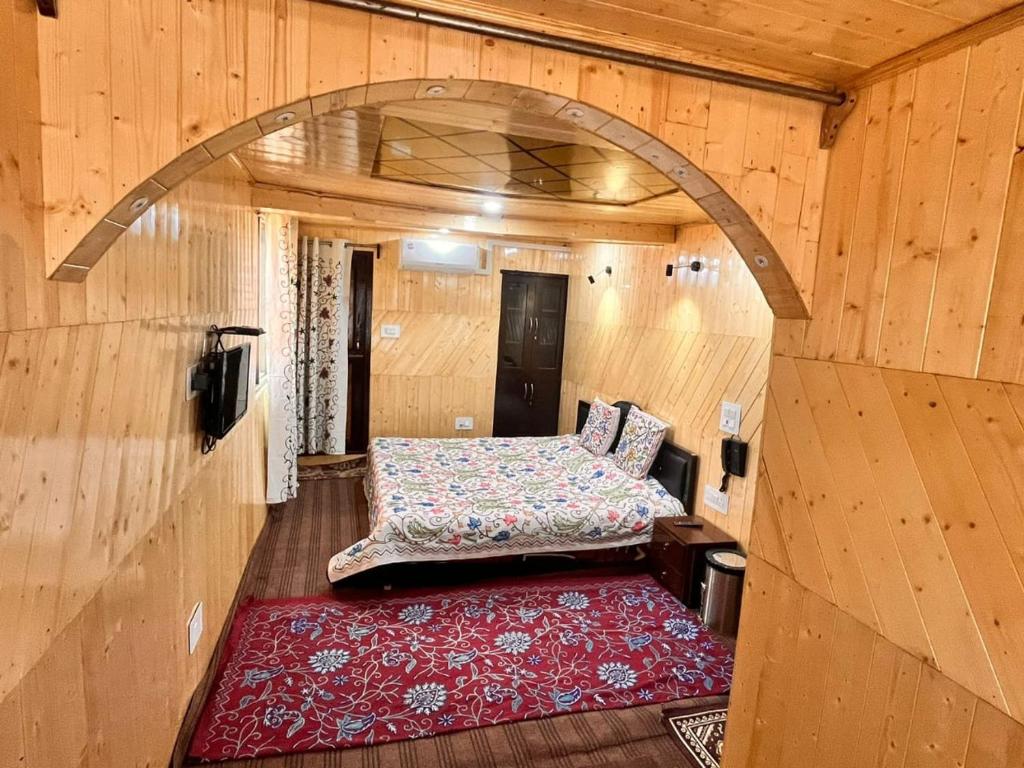 古尔马尔格Gulmarg View Cottage的小房间,配有床和红色地毯