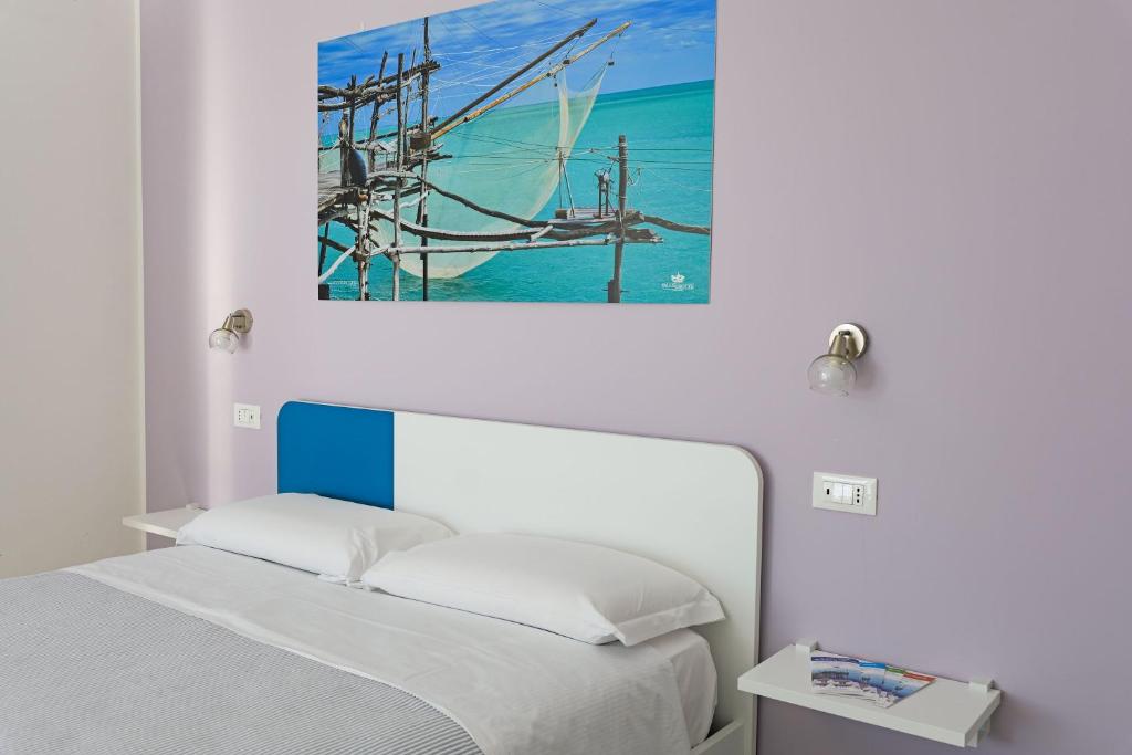 罗卡圣焦万尼Villa Caravaggio Comfort e Relax的卧室配有一张床,墙上挂有绘画作品