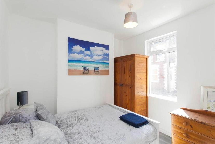 贝尔法斯特House @ Queens University的一间卧室配有一张床,享有海滩美景