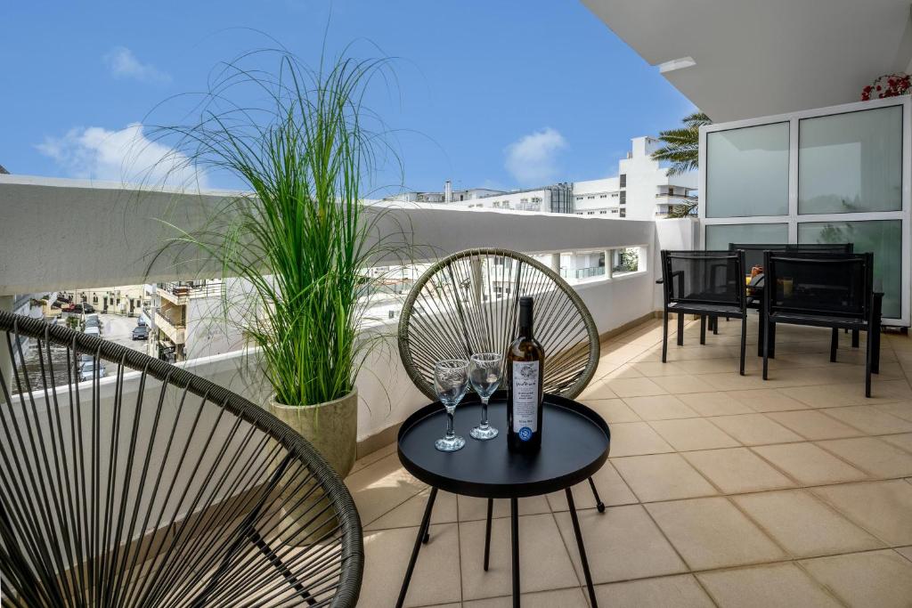 罗德镇Elli Beach Downtown Apartments的阳台配有带1瓶葡萄酒的桌子。