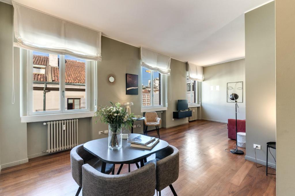 米兰圣特克拉公寓的客厅配有桌椅和窗户。