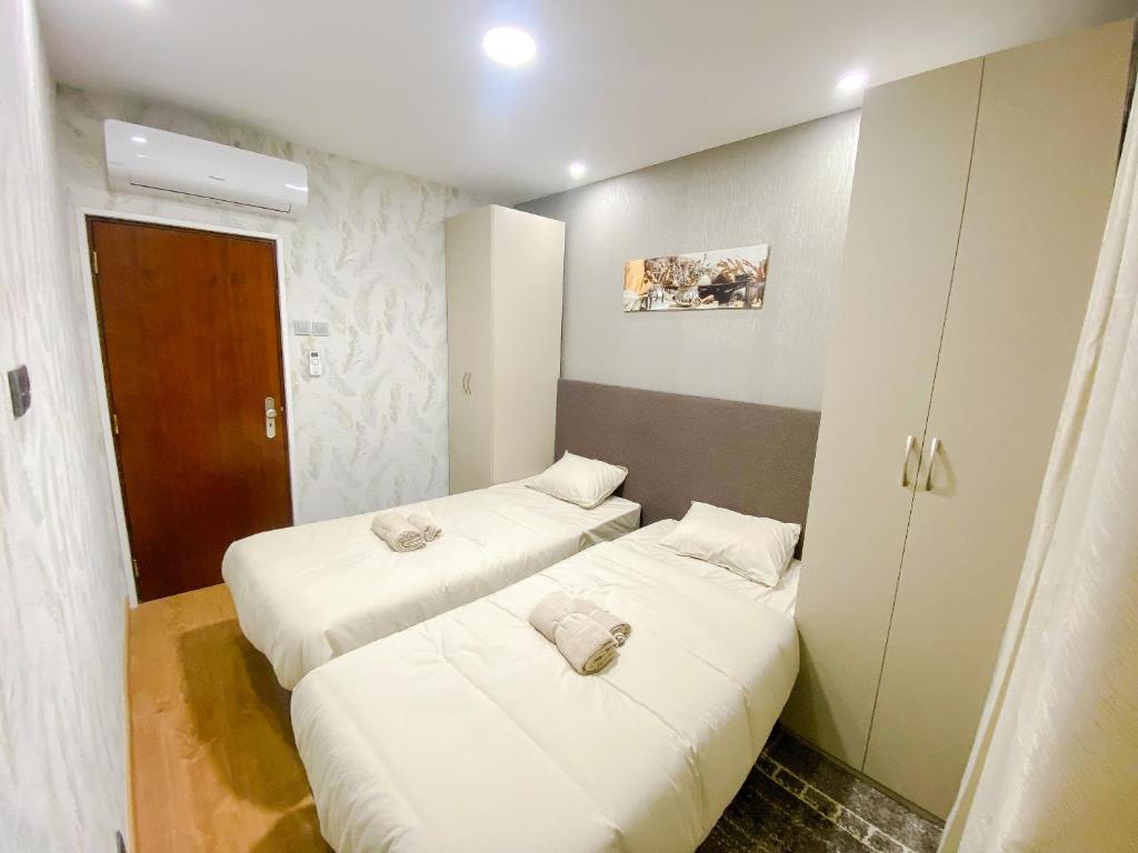 奥迪韦拉什ODIVELAS METRO RESIDENCE的小客房内的两张床,配有白色床单