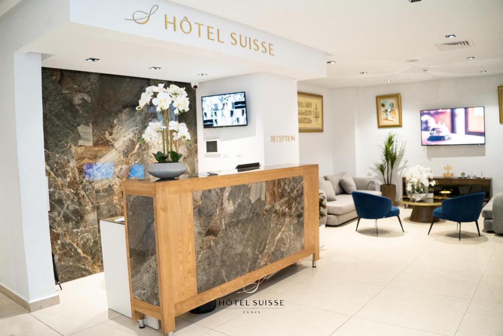 突尼斯Hôtel Suisse Tunis的大堂墙上挂有酒店标志