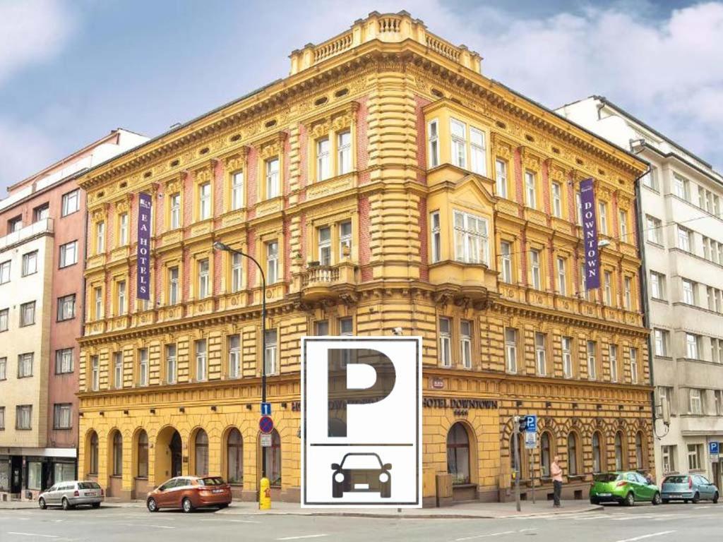布拉格EA市区酒店的一座黄色的大建筑,前面有停车标志