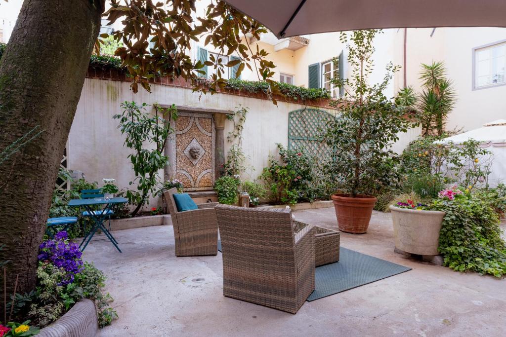 卢卡Il Cortile di Elisa & our flats的庭院配有椅子和桌子及遮阳伞